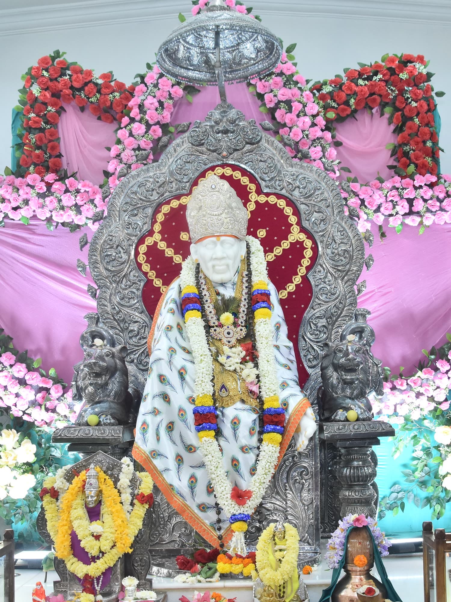 The murti before a backdrop arranged as opening lotus petals.